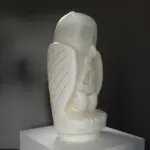 Statue einer Eule aus Stein mit elegant gefalteten Flügeln.