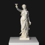 Escultura del Brindis en el Petit Palais de París, representando una mujer elegante con una copa.