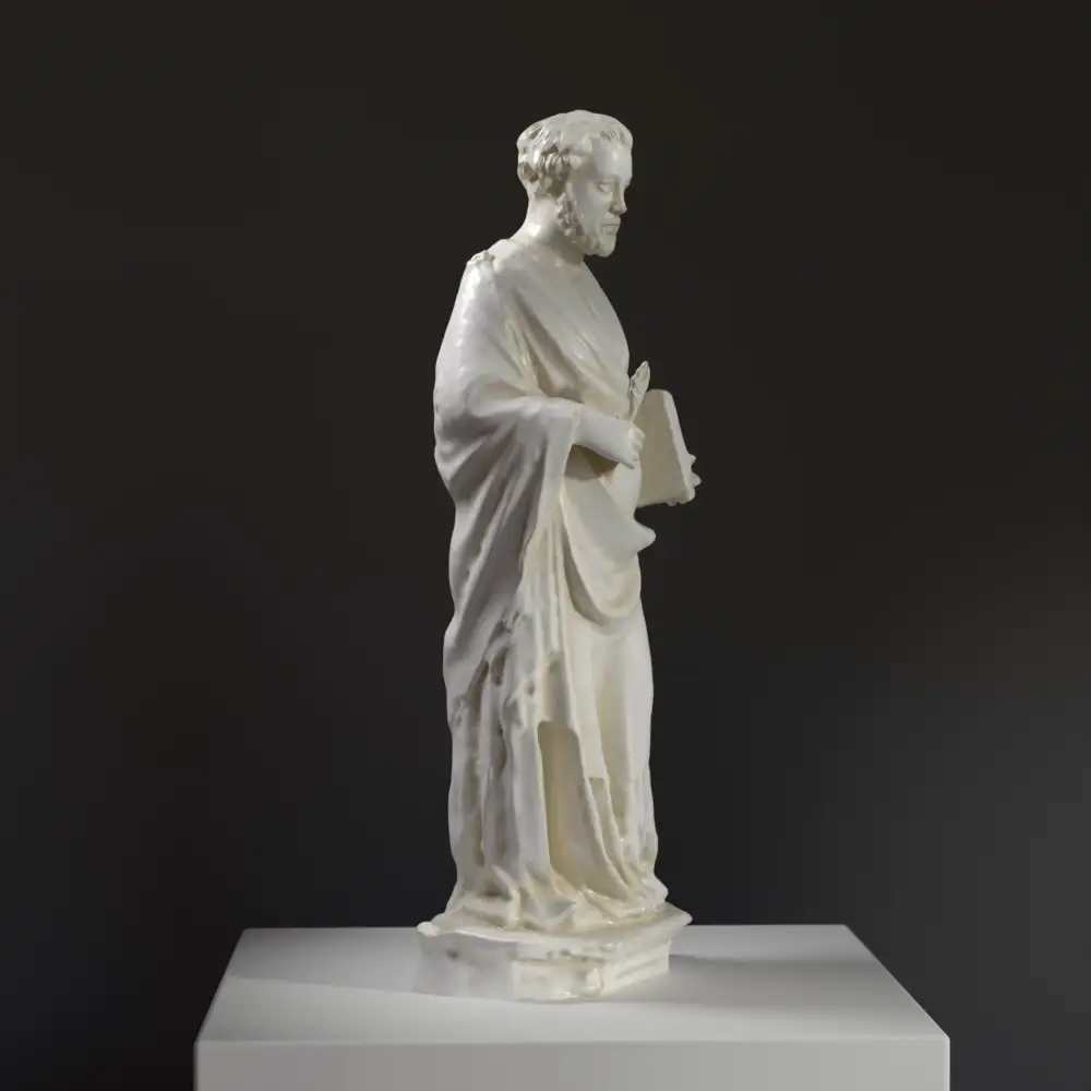 Escultura de San Lucas Evangelista con libro en mano, detalle en resina con pátina.