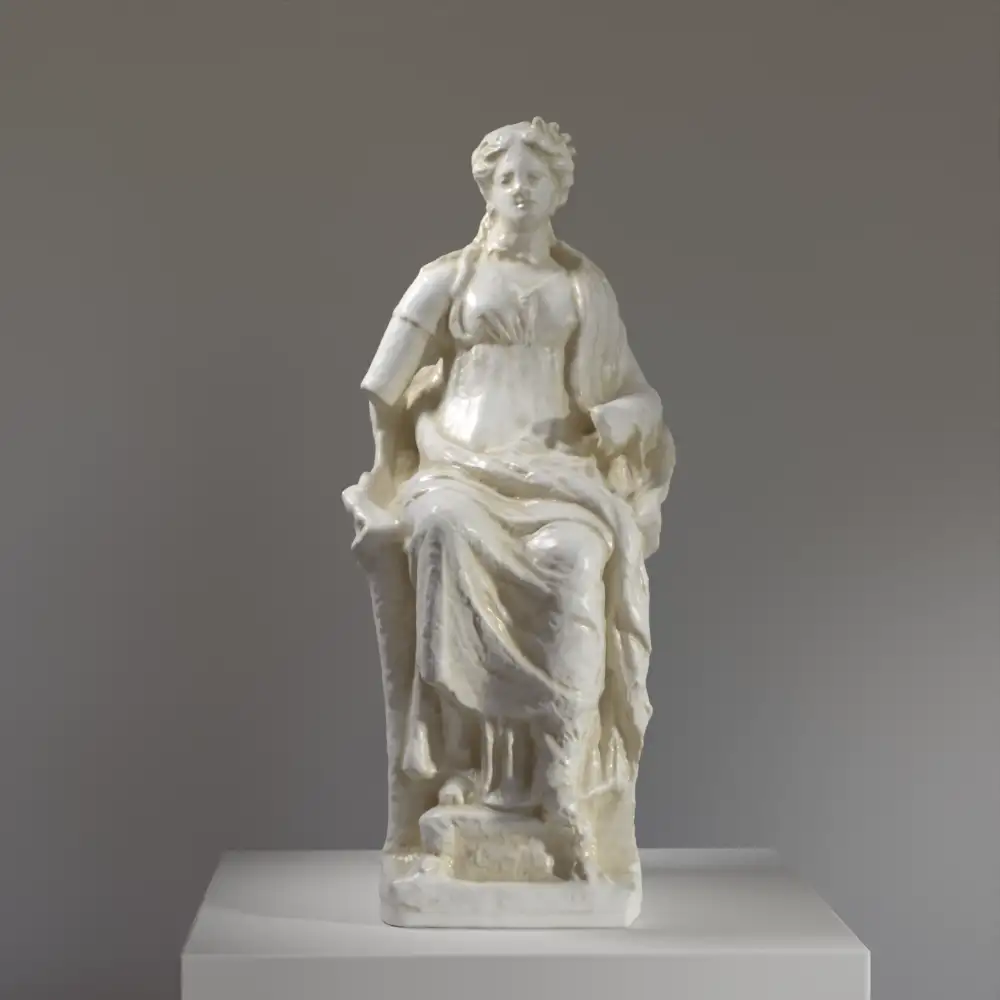 Estatua de una Mujer sentada en un trono, mostrando detalles de drapeado y forma.