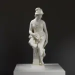 Escultura de la Alegoría de la Arquitectura, figura femenina desnuda sentada con herramientas de arquitectura.