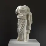 Escultura de mármol de una mujer sin cabeza, con detalles en la vestimenta.