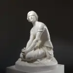 Escultura de Juana de Arco en Domremy, mostrando su figura serena y contemplativa.