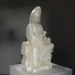 Escultura de Bodhisattva Avalokesvara sentado sobre una roca en el Museo Guimet de París.