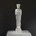 Statue du Roi Mentuhotep II debout dans le Vêtement du Jubilé, représentant l'art égyptien ancien.