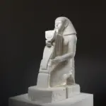Sculpture de Senenmut à genoux, présentant un cobra orné.