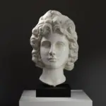 Buste représentant une tête de dieu en marbre romain, avec des détails raffinés.